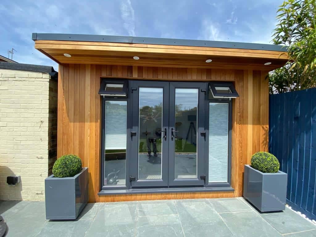 Small garden room with French doors and wooden cladding